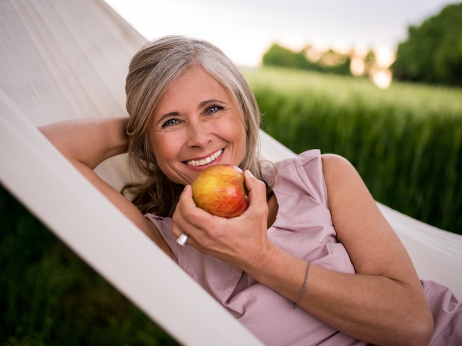 senior woman eating apple for nutrition and oral health