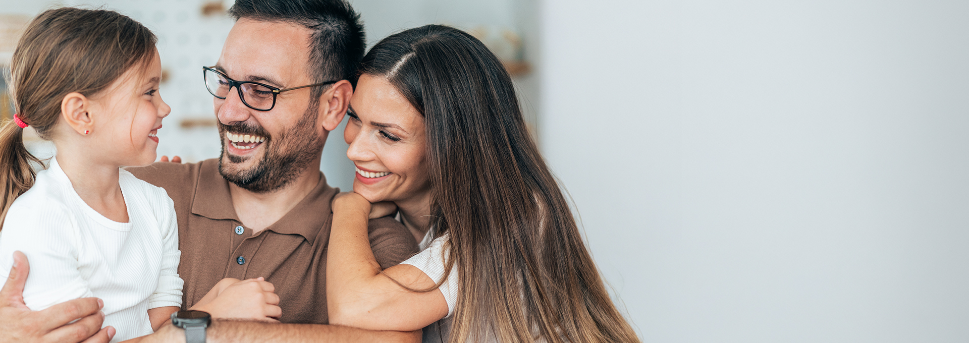 parents smiling at their young daughter